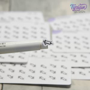 May include: A sheet of white sticker paper with multiple black and white syringe icons. A white marker with a black barcode is placed on top of the sticker sheet, with one syringe sticker on top of the marker.