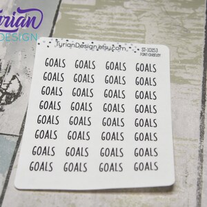 May include: A sheet of white stickers with the word "GOALS" printed in a black, sans-serif font. The stickers are arranged in rows and columns. The text "Tyrian Design" is in the upper left corner. The text "TyrianDesign.etsy.com" is at the top.