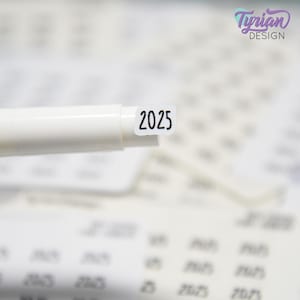 May include: A white marker pen with a white sticker on the end that says "2025".
