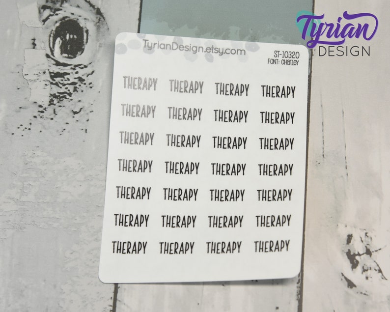 May include: A sheet of white sticker paper with 28 black "THERAPY" stickers. The stickers are arranged in four columns of seven stickers each. The text "TyrianDesign.etsy.com", "ST-10320", and "FONT: CHARLEY" is printed in black at the top of the sheet.