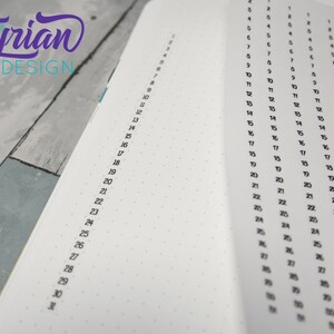 May include: A white notebook with a dotted grid pattern and numbered columns. The numbers range from 1 to 31. The notebook is open to a page with multiple columns.