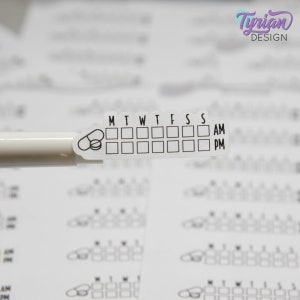 May include: A white pill reminder sticker with a pill icon and a grid for each day of the week, labelled M, T, W, T, F, S, S. The sticker also has AM and PM labels.