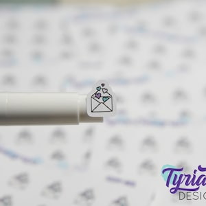 May include: A white envelope sticker with a black outline and a few colorful hearts inside. The sticker is on a white background.
