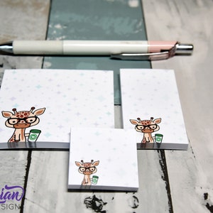 May include: Three different sizes of sticky note pads with a cartoon giraffe wearing glasses and holding a cup of coffee. The background of the note pads is white with a light blue and purple star pattern.