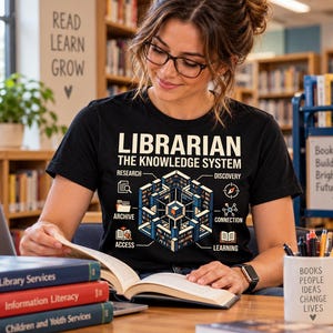 May include: A black t-shirt featuring a graphic print with the text LIBRARIAN THE KNOWLEDGE SYSTEM. The design includes a central isometric illustration of a library structure surrounded by icons and labels for research, discovery, archive, connection, access, and learning.