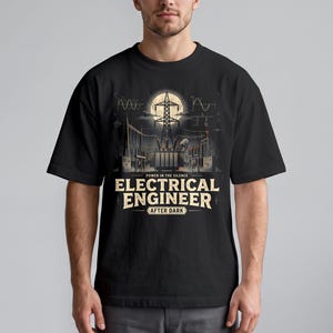 Pode incluir: Uma t-shirt preta de manga curta com um gráfico de uma subestação elétrica sob uma lua cheia. O texto diz POWER IN THE SILENCE ELECTRICAL ENGINEER AFTER DARK. O design inclui diagramas técnicos e estruturas de linhas de energia.