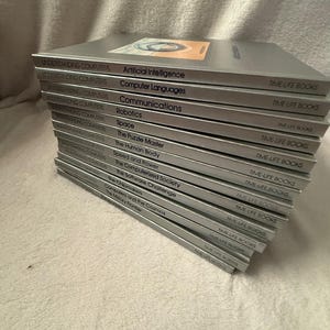 May include: A stack of twelve silver-covered books from the Understanding Computers series by Time-Life Books. Titles include Artificial Intelligence, Computer Languages, Communications, Robotics, Space, The Puzzle Master, The Human Body, and others.