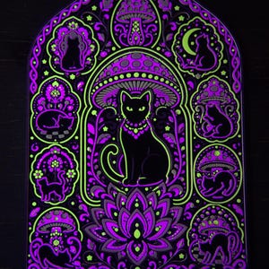 Pu&ograve; includere: Un'opera d'arte murale rettangolare con un gatto nero centrale seduto sotto un grande fungo, circondato da pannelli circolari pi&ugrave; piccoli contenenti sagome di gatti, funghi e motivi floreali in vivaci colori viola neon e verde lime.