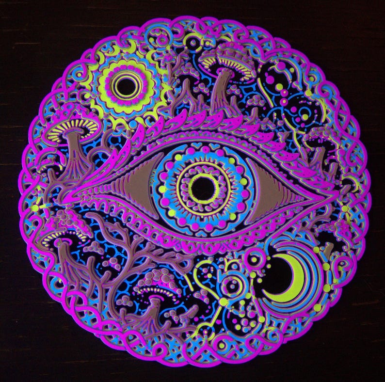 May include: A circular layered wall art piece featuring a central eye design surrounded by mushrooms, a crescent moon, and intricate geometric patterns in vibrant neon pink, electric blue, lime green, and deep brown on a black background.