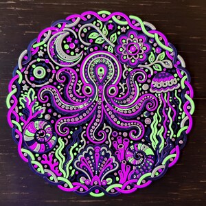 Peut inclure: Une d&eacute;coration murale circulaire repr&eacute;sentant une pieuvre centrale entour&eacute;e d'&eacute;l&eacute;ments marins complexes, notamment un coquillage, une m&eacute;duse, du corail et des coquilles en spirale. Le design utilise une palette de couleurs vives vert n&eacute;on, rose vif et violet profond.