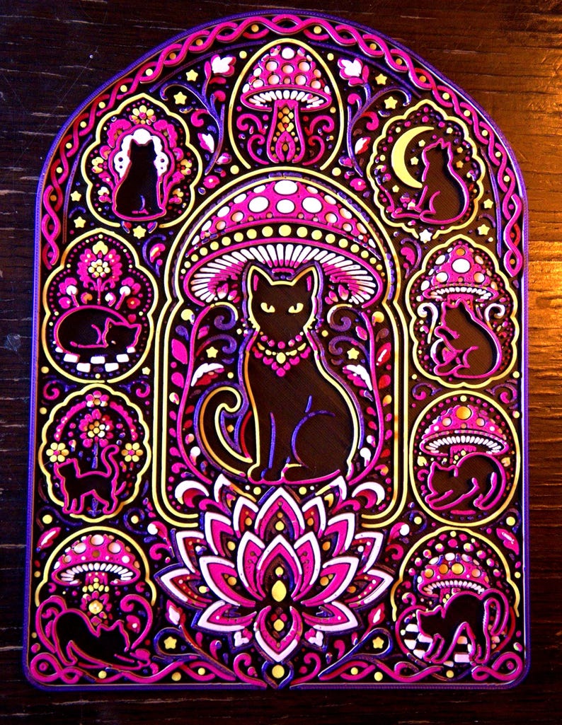 Pu&ograve; includere: Un'opera d'arte da parete a strati con un gatto nero centrale seduto sotto un grande fungo, circondato da cornici circolari pi&ugrave; piccole contenenti sagome di gatti neri, funghi, una luna crescente e un fiore di loto in rosa, viola e oro.