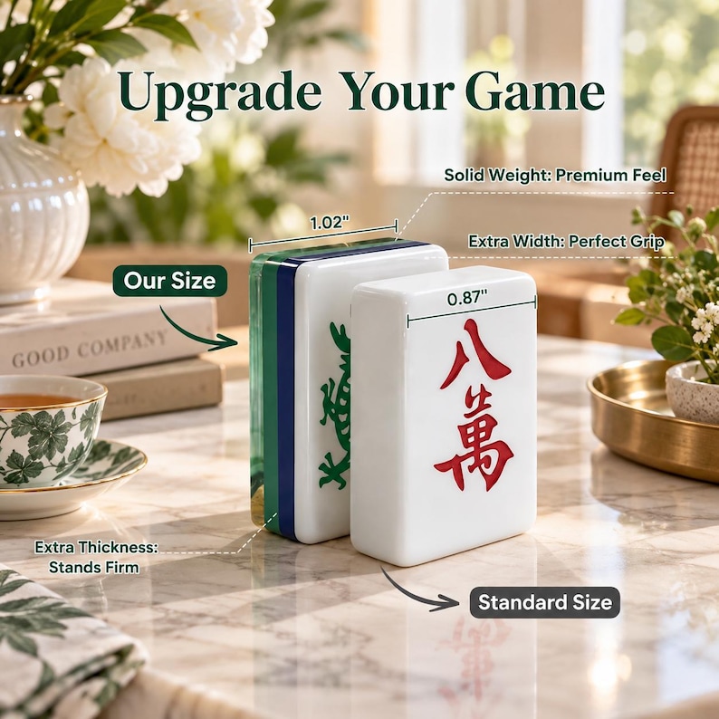 K&ouml;nnte beinhalten: Zwei wei&szlig;e Mahjong-Spielsteine werden zum Gr&ouml;&szlig;envergleich nebeneinander gezeigt. Ein Stein ist als Our Size mit 2,59 cm Breite gekennzeichnet, der andere als Standard Size mit 2,21 cm Breite. Die Steine sind mit gr&uuml;nen und roten Schriftzeichen versehen.