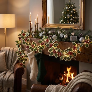 May include: A Christmas garland featuring green holly leaves, red berries, and integrated warm white fairy lights draped across a wooden fireplace mantel. Two stockings, one cream and one dark green, hang from the mantel near a lit fireplace.