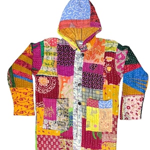 Op de afbeelding: Een jack met lange mouwen en capuchon met een levendig patchworkontwerp gemaakt van diverse kleurrijke stoffen vierkanten. Het kledingstuk is voorzien van een knoopsluiting aan de voorzijde, twee grote opgestikte zakken en zichtbare witte stiksels.
