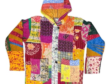 May include: A long-sleeve hooded jacket featuring a vibrant patchwork design made of various colorful fabric squares. The garment includes a front button closure, two large patch pockets, and visible white stitching throughout the quilted material.