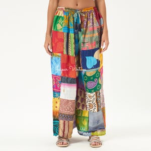 May include: Wide-leg pants featuring a vibrant patchwork design with various colorful patterns including paisley, floral, and geometric prints. The pants have an elasticized drawstring waistband and the text Jaipur Vintage is visible.