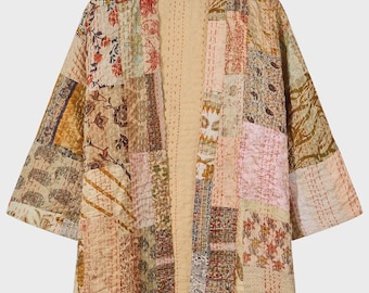 Puede incluir: Una chaqueta de patchwork que presenta una variedad de patrones florales y geométricos en tonos apagados de beige, rosa, marrón y crema. La prenda está confeccionada con detalles de acolchado de punto corrido visibles y un diseño abierto.