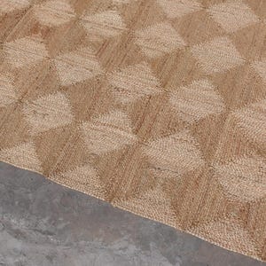May include: A rectangular area rug crafted from natural tan jute fibres, featuring a repeating geometric pattern of raised, diamond-shaped squares that create a textured, three-dimensional visual effect across the entire surface of the floor covering.