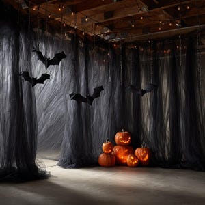 May include: A collection of five orange jack-o'-lanterns with carved faces and internal lighting, positioned in front of floor-to-ceiling black sheer fabric curtains. Several black bat silhouettes hang from the ceiling on thin chains.
