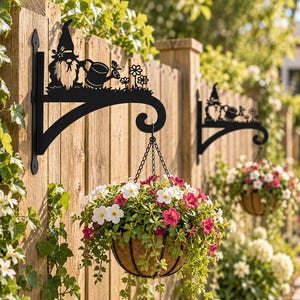 以下が含まれることがあります： 花と蝶をあしらったジョウロを持つノームのシルエットが特徴の黒い金属製ウォールブラケット。ブラケットは、黒い金属製のチェーンで吊るされた、白とピンクのペチュニアの花で満たされたハンギングバスケットを支えています。
