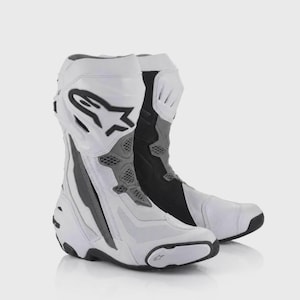 Puede incluir: Un par de botas de motocicleta blancas, negras y grises con un logotipo negro de Alpinestars en la zona superior de la espinilla, paneles de ventilación de malla, punteras reforzadas y un diseño estructurado con componentes exteriores moldeados.