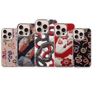 May include: Five smartphone cases arranged in a row, each featuring distinct snake-themed illustrations. The designs include a light pink background with small snakes, a dark blue background with a large red snake, a white background with intertwined black and red snakes, a white snake with red floral patterns on a red background, and a black background with colourful patterned snakes.