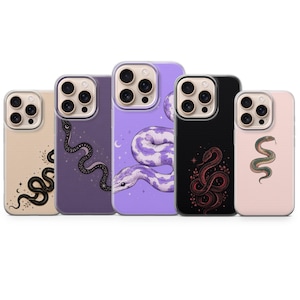 Puede incluir: Cinco fundas para smartphone dispuestas en fila, cada una con una ilustración de serpiente única. Los diseños incluyen una serpiente negra sobre beige, una negra sobre morado, una grande morada sobre lavanda, una roja sobre negro y una verde sobre rosa.