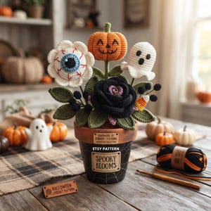 Könnte beinhalten: Ein gehäkeltes Halloween-Arrangement in einem schwarzen Topf mit Spinnennetz-Design. Der Strauß besteht aus einer Augapfel-Blume, einem orangefarbenen Kürbis, einem weißen Geist, einer schwarzen Rose und Zuckermais. Etiketten: "HANDMADE BY CROCHET PATTERN" und "SPOOKY BLOOMS".