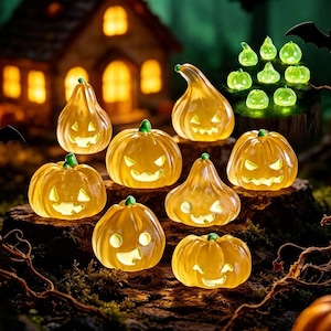 May include: A collection of translucent orange jack-o'-lanterns with carved faces and internal illumination, arranged on a dark, textured surface. The pumpkins feature various shapes and expressions, with smaller glowing green accents in the background.
