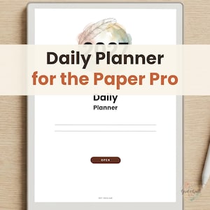 Può includere: Un tablet digitale che mostra un'interfaccia per un'agenda giornaliera 2027. Lo schermo presenta un'illustrazione di una piuma, accenti acquerellati e il testo Daily Planner for the Paper Pro. Include un pulsante con l'etichetta OPEN.