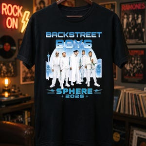 May include: A black t-shirt featuring a graphic print of the Backstreet Boys in white outfits. The text reads BACKSTREET BOYS above the group and SPHERE 2026 below. The background of the graphic shows a blue circular structure and palm trees.