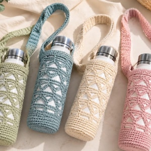 May include: Four cylindrical water bottles with silver caps, each encased in a crocheted sleeve with a geometric pattern and a matching shoulder strap. The sleeves are colored in sage green, dusty blue, cream, and dusty rose, featuring openwork.