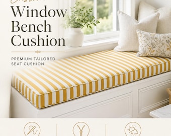 Op de afbeelding: Een rechthoekig vensterbankkussen met een geel en wit verticaal gestreept patroon. Het kussen ligt op een witte bank met drie sierkussens. De tekst op de afbeelding luidt Custom Window Bench Cushion, Premium Tailored Seat Cushion, Custom Made, Zippered Cover en Indoor / Outdoor Use.