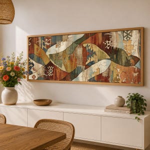 May include: A rectangular wall art piece in a light wood frame featuring a distressed, multi-colored abstract pattern with geometric shapes, textured layers of red, blue, green, and cream, and visible cracks across the surface.