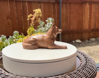 German Shepherd Figurine or Sculpture. Carved from a solid block of Walnut. In a lying pose. Available in different sizes.