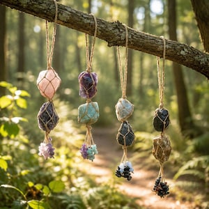 May include: Four hanging ornaments made of raw, uncut gemstones encased in tan twine macrame netting. Each ornament features two large, irregular stones stacked vertically, finished with a cluster of small, tumbled crystal chips at the bottom.