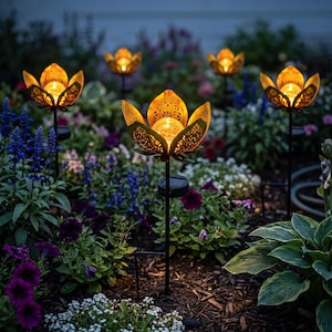 May include: A set of solar-powered garden lights shaped like lotus flowers with intricate, laser-cut metal petals in a bronze finish. Each light features a central glowing glass orb and a thin black metal stake for placement in the ground.