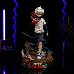 May include: A detailed anime-style figurine of a white-haired character wearing a white shirt with the number 99 and dark shorts. The character has a red energy effect on one hand, standing on a rocky base with blue lightning, labeled Hunter x Hunter.