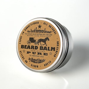Op de afbeelding: Een bruine metalen blik met een etiket waarop staat: "Leave in Conditioner - All Natural - the best for your beard" - "The World's Most Trusted and Complete Beard Care Products" - "Beard Balm Pure Unscented - No Essential Oils - by Honest Amish".