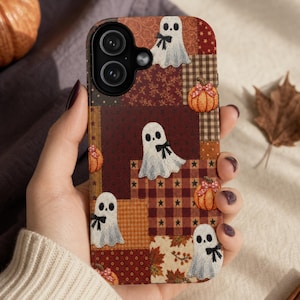 Könnte beinhalten: Eine rechteckige Handyhülle mit einem Patchwork-Design aus herbstlichen Mustern in Braun-, Orange- und Cremetönen. Das Design zeigt Illustrationen von weißen Geistern mit schwarzen Schleifen und orangefarbenen Kürbissen mit kleinen Schleifen.