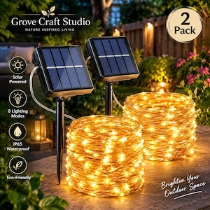 May include: A 2-pack of solar-powered string lights featuring two black rectangular solar panels on stakes connected to coiled copper wire strands with warm white LED lights. The text includes Grove Craft Studio, 2 Pack, Solar Powered, 8 Lighting Modes, IP65 Waterproof, Eco-Friendly, and Brighten Your Outdoor Space.