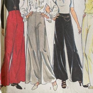 May include: A fashion illustration featuring four pairs of flared trousers in red, grey, black, and yellow. The trousers are styled with different tops, including a black top, a white blouse, a polo shirt, and a yellow top. The image is a fashion illustration.