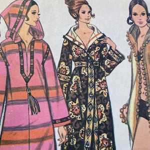 May include: Three vintage sewing patterns for women's robes. The patterns feature different styles, including a striped robe with a hood, a floral robe with a sash, and a solid robe with a beaded trim.