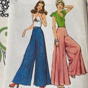 May include: A sewing pattern envelope featuring illustrations of two outfits. One shows a white halter top with red berry accents and blue wide-leg trousers. The other shows a green short-sleeve V-neck top with pink wide-leg trousers. Hip 38 inches.