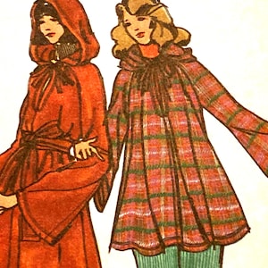 May include: A fashion illustration featuring two figures wearing outerwear. The figure on the left wears a solid red hooded cloak with a tie waist. The figure on the right wears a plaid coat with red, green, and blue stripes and a tie neck.
