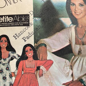 Puede incluir: Un patrón de costura vintage que muestra a una mujer con un vestido blanco con ribete de encaje. El patrón es para un vestido "Petite Able" e incluye instrucciones para ajustar el tamaño. El texto "Hancock Paducoh Ky" también es visible en el patrón.