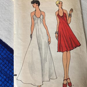 May include: Illustration of two halter dresses. One is a floor-length white gown, and the other is a knee-length red dress. Both dresses have a halter neckline and are sleeveless. The dresses are drawn on a light-colored background.
