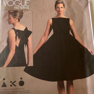 May include: A black dress pattern from Vogue Patterns. The dress has a scoop neck and a bow detail in the back. The pattern is for a dress with a full skirt.