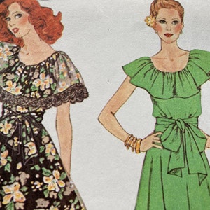 May include: Two women wearing dresses with ruffled necklines and tied sashes. The dress on the left is black with a floral print and lace trim. The dress on the right is green.
