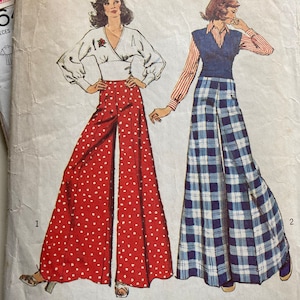 May include: A vintage sewing pattern featuring two women wearing wide-legged trousers. The woman on the left is wearing red trousers with white polka dots, while the woman on the right is wearing blue and white plaid trousers. Both women are wearing long-sleeved tops. The pattern is labelled "56" and "16 pieces".